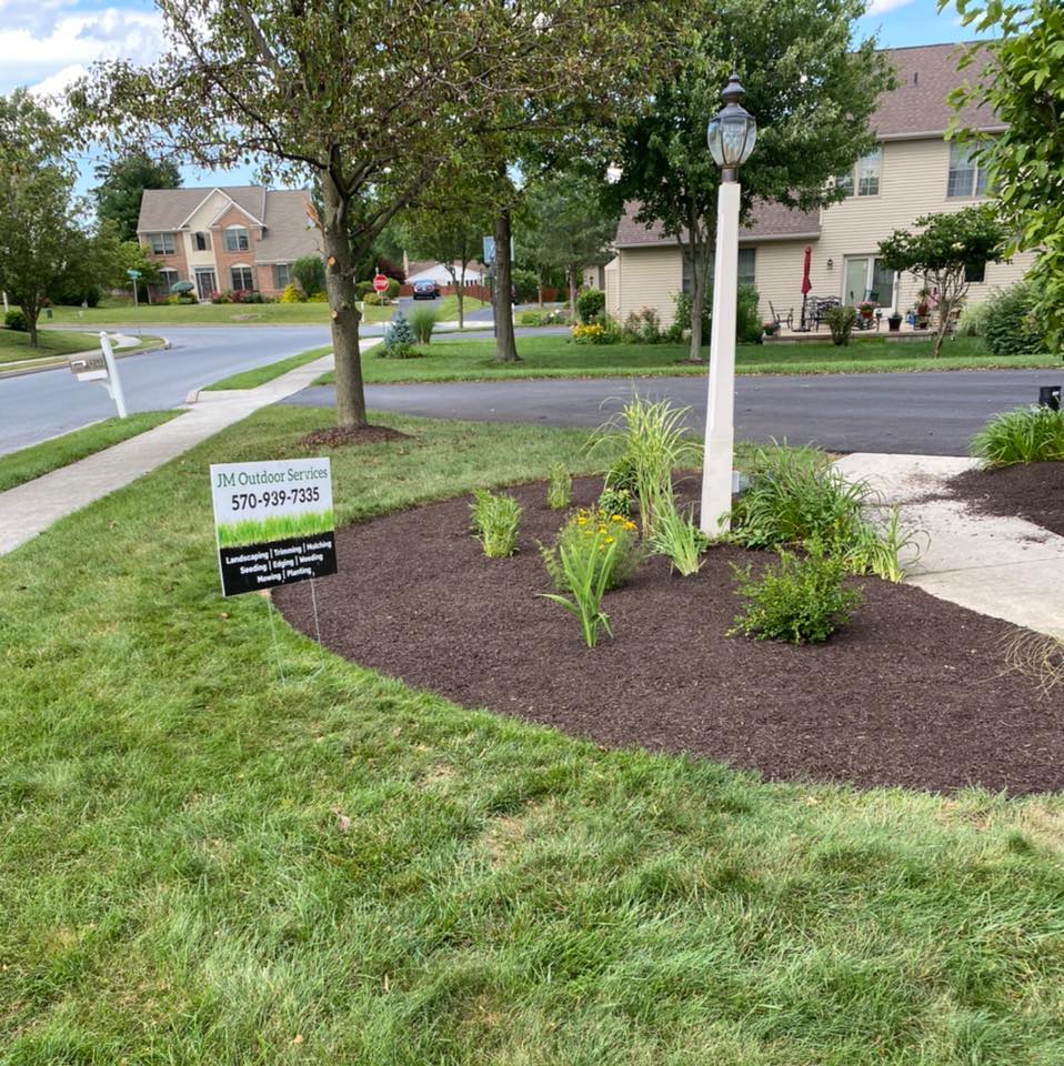 JM Outdoor Services sign at a local landscape project